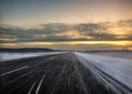 Airport runway at dawn surrounded by snow Royalty Free Stock Photo
