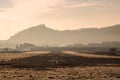 Airport runway with direction signs surrounded by grassy ground and hills with trees at sunset Royalty Free Stock Photo