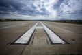 Airport runway landing and take off marks with clouds in the distance Royalty Free Stock Photo