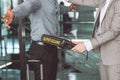 Airport security check officer using metal weapon scanner detector check every passenger