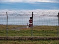 Airport security perimeter fencing system with razor wire with SRA security restricted area stop sign and airplanes