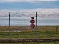 Airport security perimeter fencing system with razor wire with SRA security restricted area stop sign and airplanes