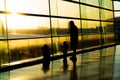 Airport, silhouette of father with kids, blurred aircrafts behind tall windows, Dublin Ireland, sunrise