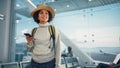 Airport Terminal: Happy Traveling Black Woman Waiting at Flight Gates for Plane Boarding, Uses Mob Royalty Free Stock Photo