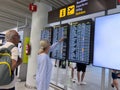 Airport timetable, people pointing timetable departure arrival