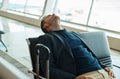 Airport, travel and tired businessman sleeping while waiting to board his plane for work in city. Exhausted, rest and Royalty Free Stock Photo