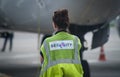 Airport unidentified security guard girl stands near the plane Royalty Free Stock Photo