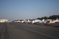 Airport view with Cessna airplanes lined up on the airfield, blue sky and trees background