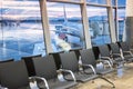 Airport waiting area. plane and dramatic sky behind the windows. modern airport terminal waiting room Royalty Free Stock Photo