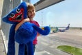 Airport. Waiting room. A little girl with a big blue toy is waiting for the plane to take off. Royalty Free Stock Photo