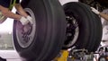 Airport worker checking chassis. Engine and chassis of the passenger airplane under heavy maintenance. Engineer checks Royalty Free Stock Photo