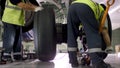 Airport worker checking chassis. Engine and chassis of the passenger airplane under heavy maintenance. Engineer checks Royalty Free Stock Photo