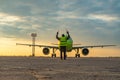 Airport worker standing in front of the airplane at the airport