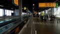 Airport worker in uniform walking to departure hall, passengers moving to gate