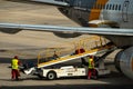 Airport workers loading baggage to an airplane