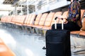 Airport Young female passenger with her luggage sitting in terminal.