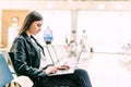 Airport Young female passenger with laptop sitting in terminal hall while waiting for her flight. Air travel concept with young Royalty Free Stock Photo