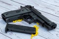 airsoft handgun with yellow bb, on white wooden background