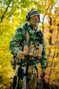 Airsoft, man in uniform stand with sniper rifle on autmn forest background. Side view