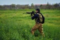 Airsoft player in military uniform aims at the enemy