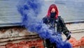 Airsoft red-hair woman in uniform with violet smoke on roof. Close up soldier. Horizontal photo