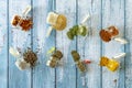 Airtight spice jars overturned on blue wooden background with pepper, oregano, cayenne, sesame, paprika, curry Royalty Free Stock Photo