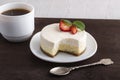 Airy cheese dessert, teaspoon and cup of coffee. New York dessert cheesecake