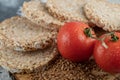 Airy crispbread, tomatoes and raw buckwheat on marble surface