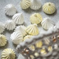 Airy meringue in form of drop, close up shot. White and yellow meringues on parchment paper, fresh from oven. Delicate