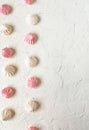 the airy meringue white and pink lies on a light Desk in rows and columns.