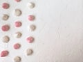 the airy meringue white and pink lies on a light Desk in rows and columns.