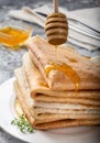 Airy sweet pancakes on a plate. A mountain of pancakes on the table. pancakes with honey.