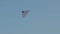 Airy white kite flying in blue cloudless sky copy text space. Low angle view of weightless toy hovering in air slow