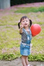 Aisa cute naughty lovely child girl with V pose play with balloon have fun outdoor in summer park happy smile happiness childhood Royalty Free Stock Photo