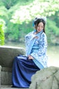 Aisan Chinese woman in traditional Blue and white Hanfu dress, kill time in a famous garden