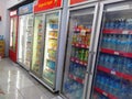 Aisle with various kinds of drinks on the Freezer shelves inside Alfamart