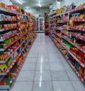 Aisle with various kinds of snacks and drinks on the shelves inside Alfamart (one of Indonesia local franchice Mini market