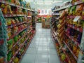 Aisle with various kinds of snacks on the shelves inside Minimarket