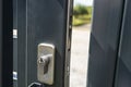 Ajar gate in a modern panel fence in anthracite color, lock and latch visible. Royalty Free Stock Photo