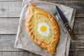 Ajarian khachapuri with egg on wooden background