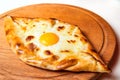 Ajarian traditional flatbread khachapuri or hachapuri with cheese, egg and butter on a plate