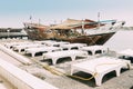 Ajman, UAE, United Arab Emirates - May 26, 2021: Dhow sailboat near pier with deck chairs in summer day. Sailboat moored