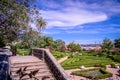 Ajuda botanical garden, several trees and staircase, as background 25th of April Bridge over the Tejo and Christ the King, Lisbon