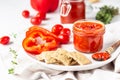 Ajvar pepper mousse or pindjur red vegetable spread made from paprika and tomatoes in glass jar on light stone table. Royalty Free Stock Photo