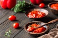 Ajvar pepper mousse or pindjur red vegetable spread made from paprika and tomatoes in wooden bowl on the rustic wooden table. Royalty Free Stock Photo