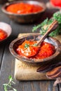 Ajvar pepper mousse or pindjur red vegetable spread made from paprika and tomatoes in wooden bowl on the rustic wooden table. Royalty Free Stock Photo