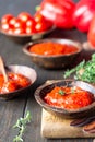 Ajvar pepper mousse or pindjur red vegetable spread made from paprika and tomatoes in wooden bowl on the rustic wooden table. Royalty Free Stock Photo