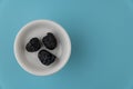 Ajwa Dates or `Kurma Ajwa` in a small plate isolated on light blue background. Prophet dates is one of the special fruit of Arabic Royalty Free Stock Photo