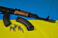 Ak-47 rifle, magazines and ammunition lying on a blue-yellow Ukrainian flag