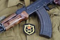 AK 47 with Soviet Army Artillery shoulder patch on khaki uniform background